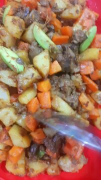 Close-up video of sambal goreng kentang ati ampela, a traditional Indonesian dish made with fried potatoes, chicken liver, and gizzard cooked in spicy chili sambal and aromatic spices.
