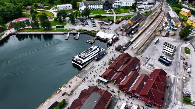 Aerial overview of passengers disembarking ferry in Flam harbor with ferry terminal railway and waterfront