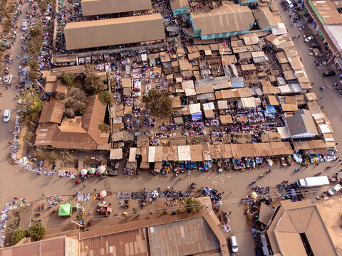 Aerial view of the bustling Loitokitok market with numerous stalls, vendors, and shoppers navigating the crowded pathways under the bright daylight in Loitokitok, Kajiado County, Kenya.