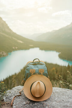 A traveler's hat and bag with a mountain backdrop.