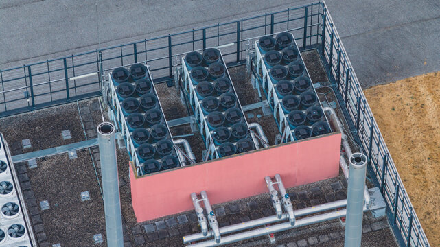 Aerial view of industrial cooling infrastructure on a rooftop, featuring rows of dry coolers, HVAC systems, and mechanical piping for thermal management in Valence, Auvergne-Rhone-Alpes, France.