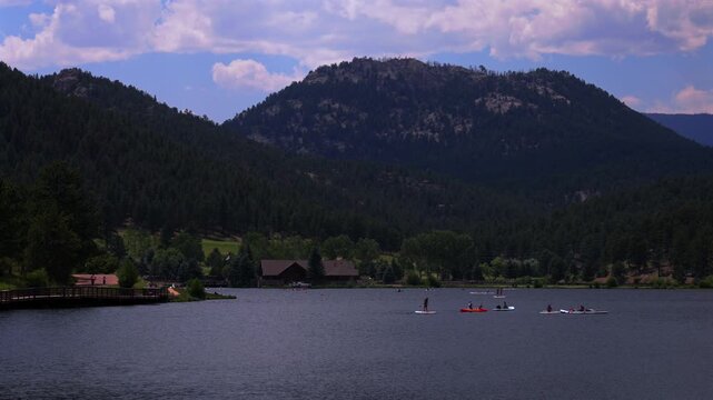 Summer Evergreen Lake paddleboarding canoe kayak boats water sports aerial drone Evergreen Colorado foothills Denver Golf Course Front Range Rocky Mountain sunny cloudy morning haze pan left
