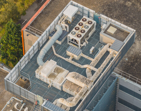 Aerial view of a rooftop mechanical plant featuring industrial HVAC cooling units, ventilation ducts, and piping on a modern building in Valence, Auvergne-Rhone-Alpes, France.