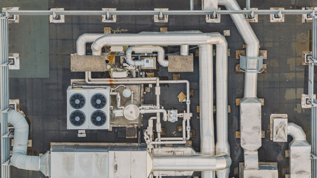 Aerial view of modern rooftop HVAC installation with ventilation ducts, cooling equipment, and mechanical infrastructure on a building in Valence, Auvergne-Rhone-Alpes, France.