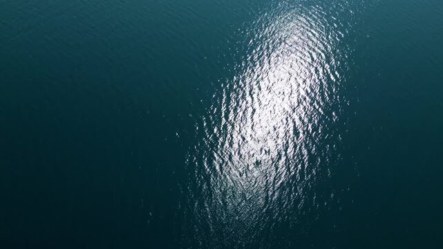 Aerial Top Down View of Bright Sun Reflection on Deep Blue Sea Water