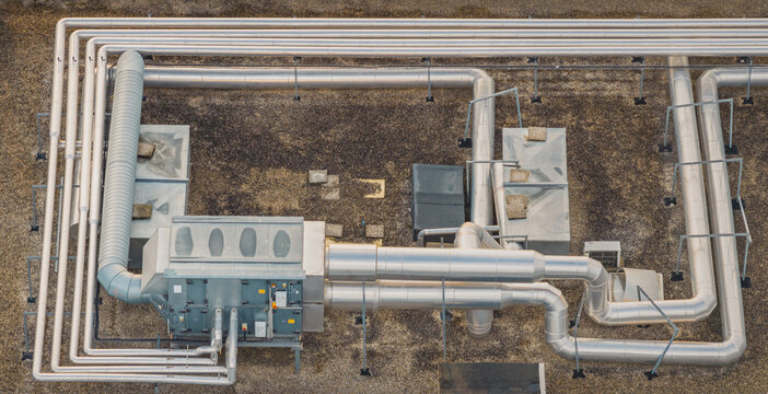 Aerial view of industrial HVAC system and process piping on a factory rooftop in Valence, Auvergne-Rhone-Alpes, France.
