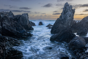 Fototapeta premium Incoming tide crashing into rocks