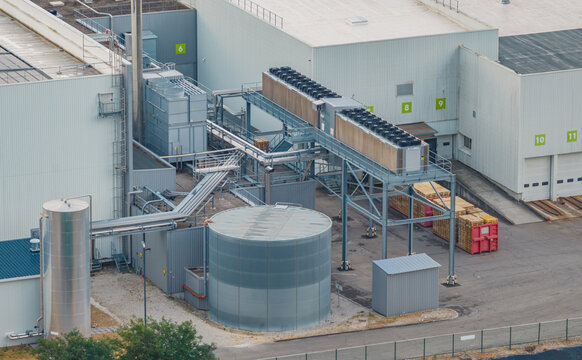 Aerial view of modern industrial cooling systems, process tanks, utility pipelines and production buildings at a manufacturing facility in Valence, Auvergne-Rhone-Alpes, France.