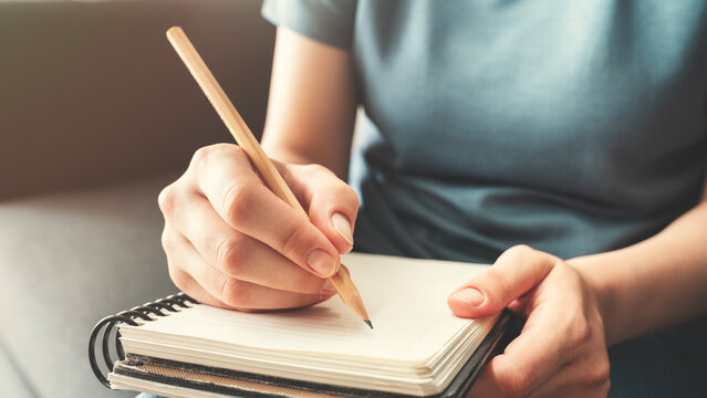 Woman hand writing on notebook