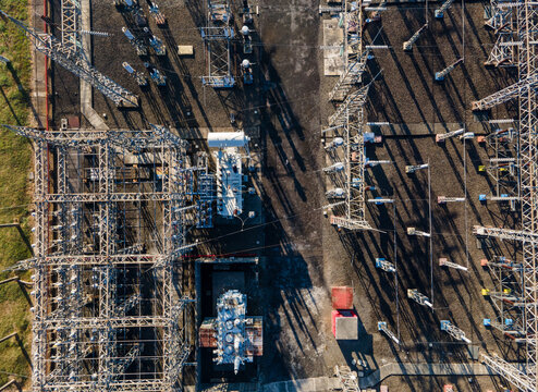 Aerial view of an electrical substation with metal structures, transformers, and power lines in Purwokerto, Central Java, Indonesia.