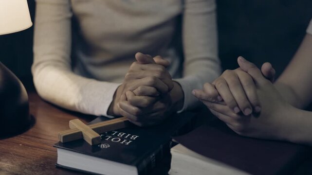 Two people praying hand in hand, sharing faith and hope, offering love, care, support, and comfort during a meaningful spiritual moment.