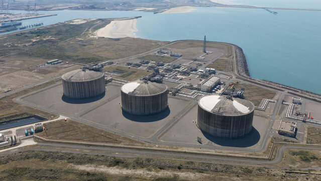 Aerial view of the Dunkirk LNG Terminal with its large storage tanks, industrial infrastructure, and coastal setting in Loon-Plage, Hauts-de-France, France.