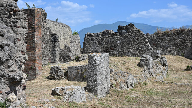 Various Ruined Structures in Ancient Pompeii on Clear Day with Mount Vesuvius in the Distance