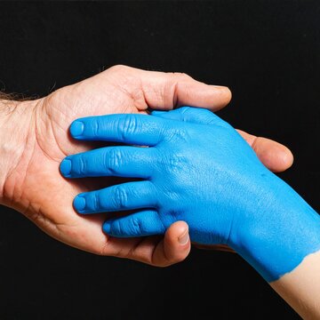 Blue Gloved Hand Grasping Bare Hand in Close Up