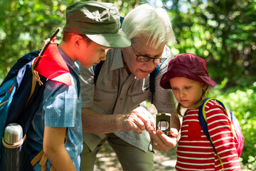 Naklejka premium Grandparent teaching kids nature photo