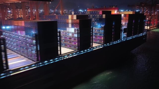 Unloading large cargo containers seaport. Loading freight sea port. Top aerial drone view. Lot big boxes rows, ship delivery ocean harbor. Shipping night. Goods export import. Industrial Marine dock.