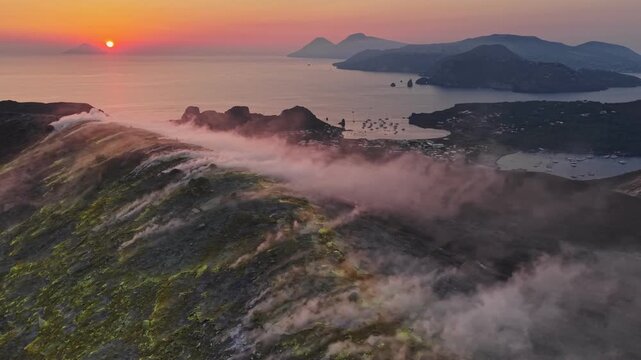 Volcano fumaroles smoking on Vulcano island crater at sunset, scenic aerial view of Aeolian archipelago in Italy. Dramatic sunset over Vulcano island volcanic crater with active steam vents, Sicily