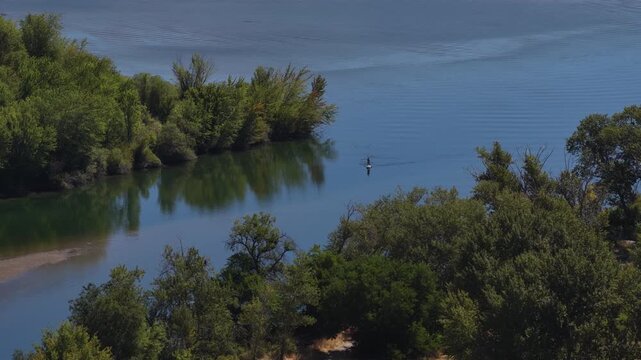 Aerial of Columbia River forested shoreline and kayaks in Wenatchee Washington in summer