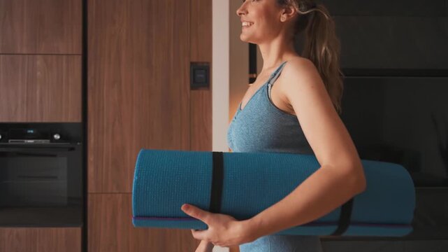 silhouette young happy woman body part going to do sports at home room, hands holds karimat mat in hands, sportswear suit blue top leggings. aerobics sport fit yoga workout domestic fitness modern