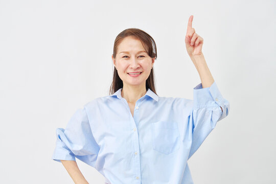 白背景で上を指差す女性
