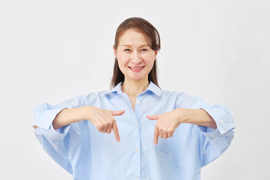 白背景で下を指差す女性