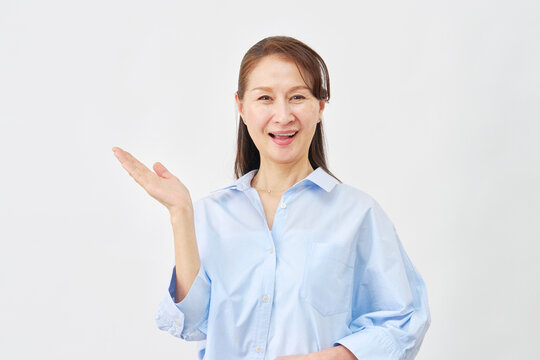 白背景で手のひらで左を指す女性