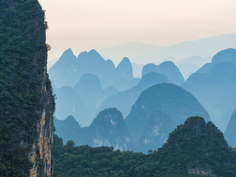 Aerial view of karst mountains in Yangshuo County with layered peaks and misty atmosphere in Guilin, Guangxi, China.