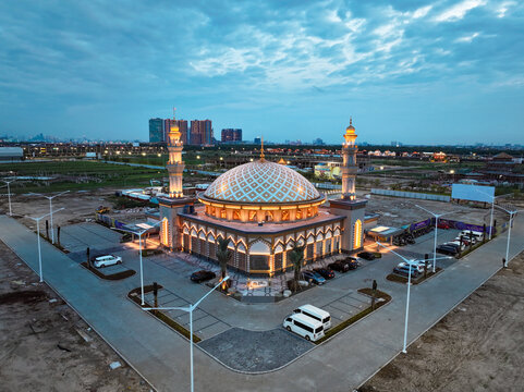 Aerial view of Masjid Al-Ikhlas PIK with its prominent dome and minarets, surrounded by a parking lot and urban development in Jakarta Utara, Daerah Khusus Ibukota, Indonesia.