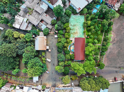 Aerial view of SDN Kembangan Utara 2 PT3 PG school grounds featuring a basketball court, trees, and surrounding residential rooftops in Kecamatan Kembangan, Daerah Khusus Ibukota, Indonesia.