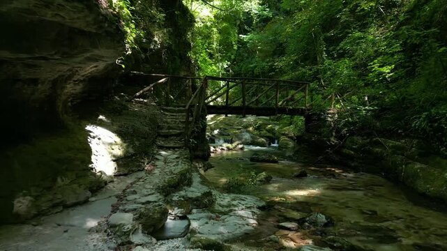 Rock gap leading to a truss footbridge 4k drone