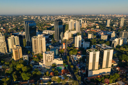 Aerial view of Paseo La Galeria and surrounding modern high-rise buildings, urban infrastructure, and lush green trees in Asuncion, Asuncion, Paraguay.