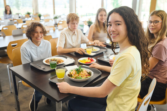 Teenagers enjoying a lunch together in a bright and cheerful school cafeteria
