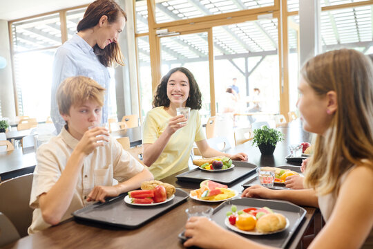 Students enjoying a healthy lunch together in a bright school cafeteria