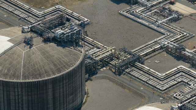 Aerial view of Dunkirk LNG Terminal showing large storage tanks and complex industrial piping infrastructure in Loon-Plage, Hauts-de-France, France.