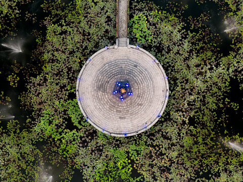 Aerial view of the circular Alun Alun Tugu Malang platform surrounded by a lotus pond with fountains in Malang, East Java, Indonesia.