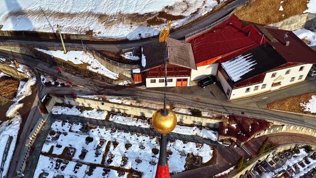 Aerial view of the church spire and snow-covered cemetery in the alpine village of Nauders, Tyrol, Austria.