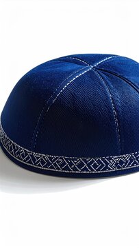 A close-up of a dark blue, textured skullcap with silver decorative stitching