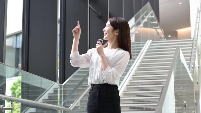 ピンマイクを持ってプレゼンテーションをする20代の日本人女性