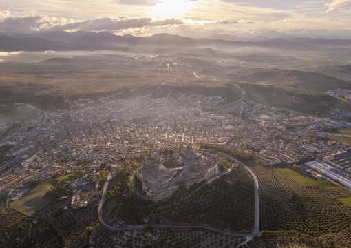 Aerial view of Fortaleza de la Mota overlooking the historic town of Alcala la Real, surrounded by olive groves and rolling hills in Alcala la Real, Andalucia, Spain.