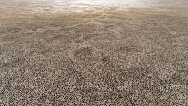Aerial view of the dried-up lake bed of Cavuscugol with intricate cracked earth patterns stretching across the landscape in Cavuscugol, Konya, Turkiye.