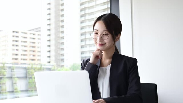 ノートパソコンを使いながら考える30代日本人女性