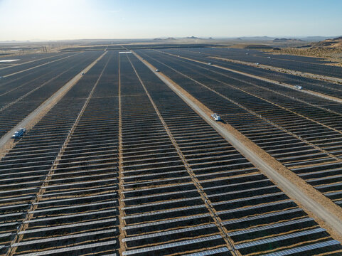 Aerial view of the Mojave Desert clean energy solar farm with rows of photovoltaic panels stretching across the arid landscape in Mojave, California, United States.