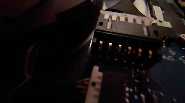 Macro close-up shot of a laptop circuit board, showcasing internal wire connectors and speaker (SPK) plug sockets with intricate electronic components. Ideal for technology, hardware repair
