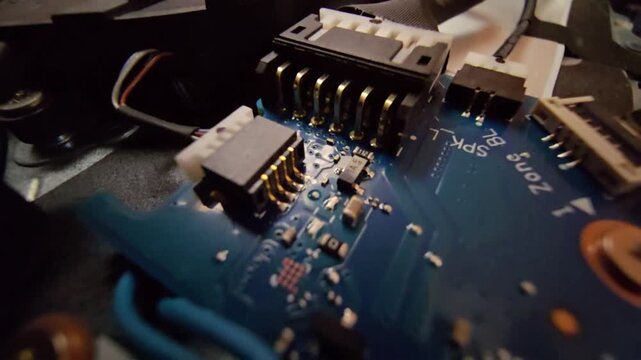 Macro close-up shot of a laptop circuit board, showcasing internal wire connectors and speaker (SPK) plug sockets with intricate electronic components. Ideal for technology, hardware repair
