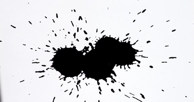 Ink splashes on a white sheet of paper. Black paint stains on a white background.