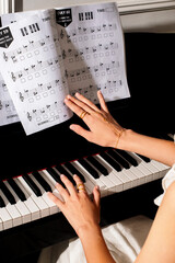 pianist female hands wearing jewelry playing piano and music notes © Елизавета Фильченко
