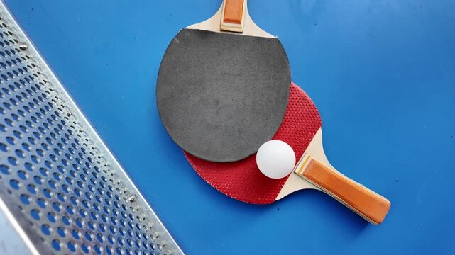 Table tennis paddles and ball on ping pong table