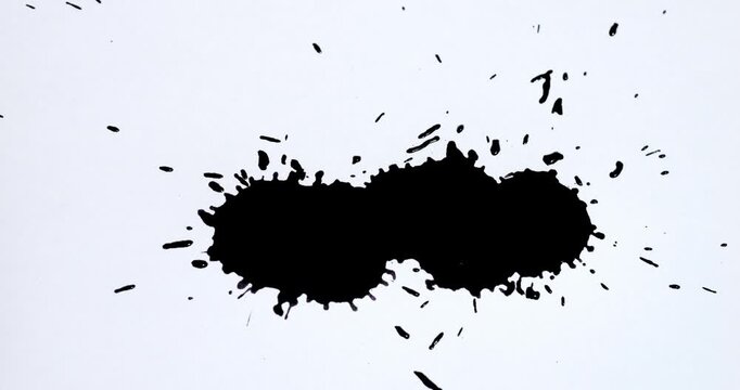 Ink splashes on a white sheet of paper. Black paint stains on a white background.