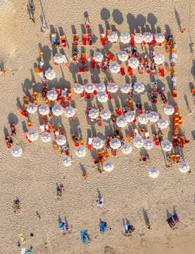 Aerial view of Tel Aviv Beach with colorful umbrellas and people relaxing on the sand in Tel Aviv-Yafo, Tel Aviv District, Israel.