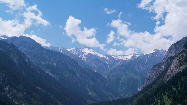 Snowcapped Hindu Kush mountains rise above Upper Dir Valley beneath scattered clouds, Khyber Pakhtunkhwa, Pakistan
